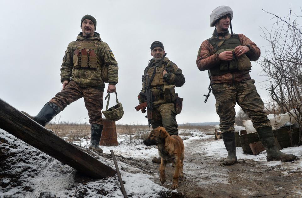 File photo: Service members of the Ukrainian armed forces stand next to a puppy at combat positions near the line of separation from Russian-backed rebels in the Donetsk region, Ukraine (REUTERS)