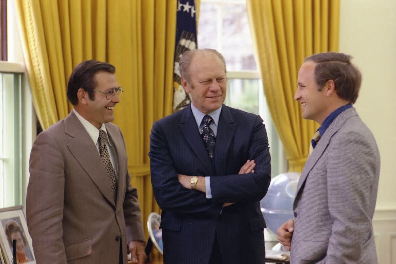 File photo of former US President Ford talking with his Chief of Staff Rumsfeld and Rumsfeld's assistant Cheney in the Oval Office