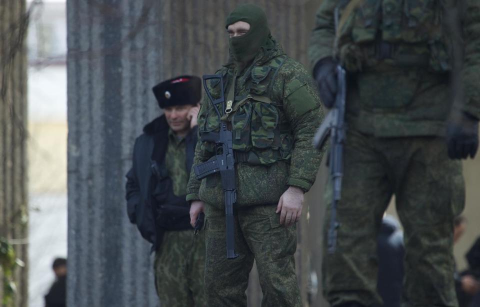 Unidentified gunmen wearing camouflage uniforms block the entrance of the Crimean Parliament building in Simferopol, Ukraine, Saturday, March 1, 2014. The discord between Russia and Ukraine sharpened Saturday when the pro-Russian leader of Ukraine's Crimea region claimed control of the military and police and appealed to Russia's president for help in keeping peace there. (AP Photo/Ivan Sekretarev)