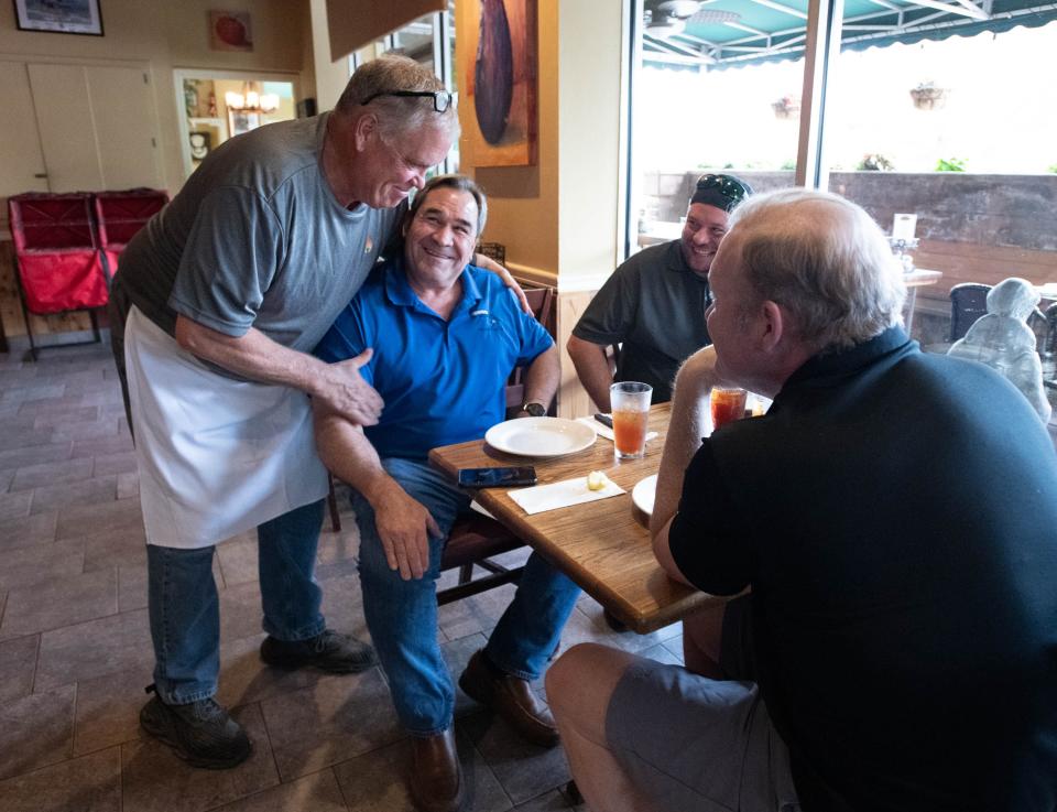 From left, owner Ted Lamarche greets regulars Robert Hepworth, Aaron Willis, and Jason Jones at Tuscan Oven in Pensacola on Tuesday, April 2, 2024.