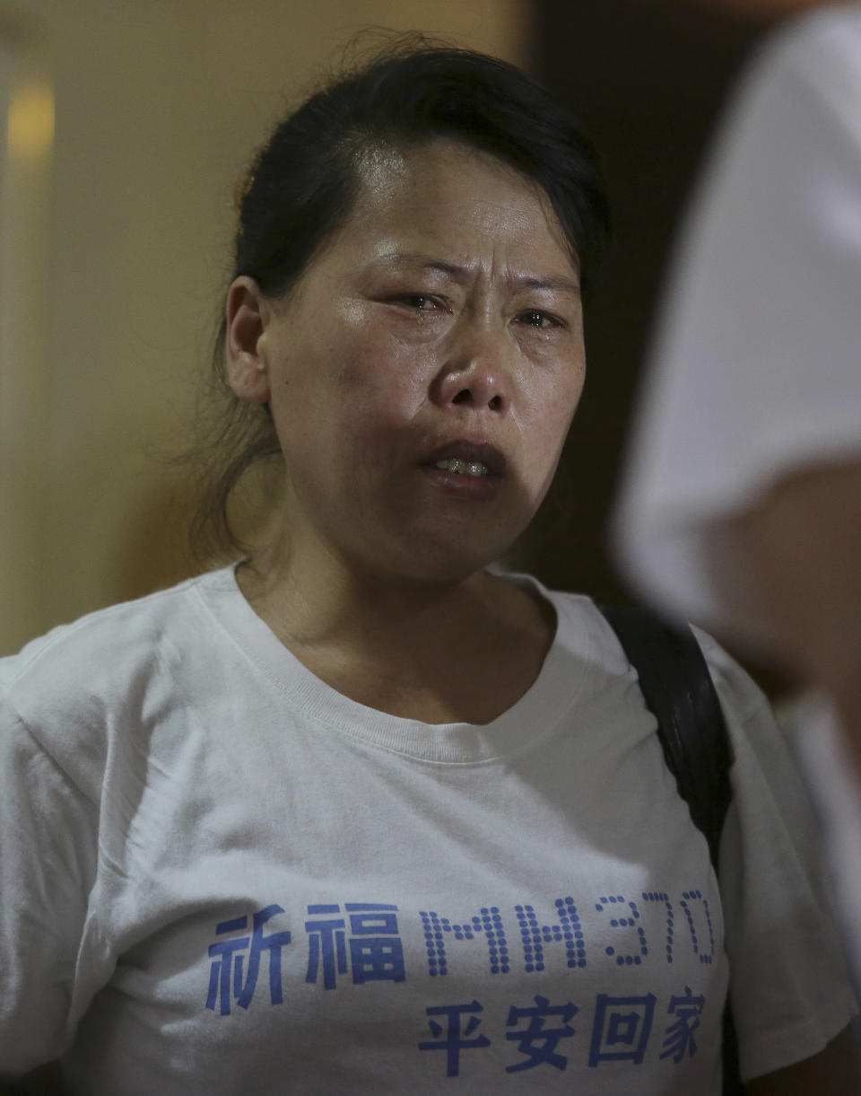 A newly arrived Chinese relative of passengers on board the missing Malaysia Airlines flight MH370 breaks into tears as she speaks to reporters at a hotel in Subang Jaya, Malaysia, Sunday March 30, 2014. Several dozen Chinese relatives of passengers on Flight 370 arrived in Malaysia Sunday to demand more information about what happened to the airliner that has been missing for more than three weeks, saying there has not been enough information on what happened to their loved ones. Her T-shirt reads: "Praying that MH370 returns home safely." (AP Photo/Aaron Favila)