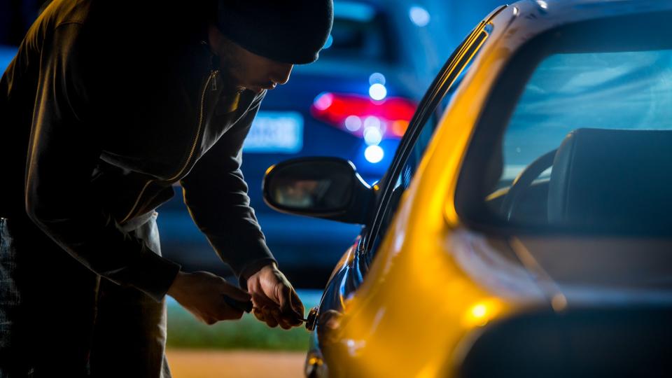 Car thief stealing a car.