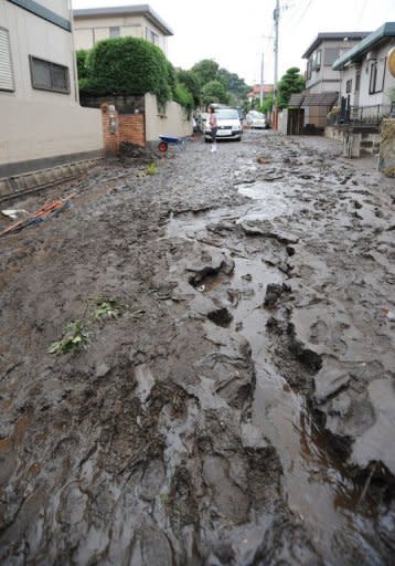 A road is covered in mud in a residential area after heavy rain fell at Kumamoto city on Japan's southern island of Kyushu. At least 17 people died, 20 were missing and 50,000 were ordered to evacuate as the heaviest rainfall on record pounded Kyushu, officials and reports said Thursday