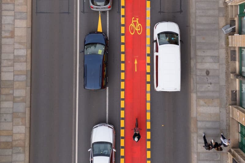 An aerial view taken with a drone shows a cycle lane painted in red at the Blaues Wunder bridge over the Elbe. The cycle lane is part of a trial with which the city wants to test a new division of traffic space. Sebastian Kahnert/dpa
