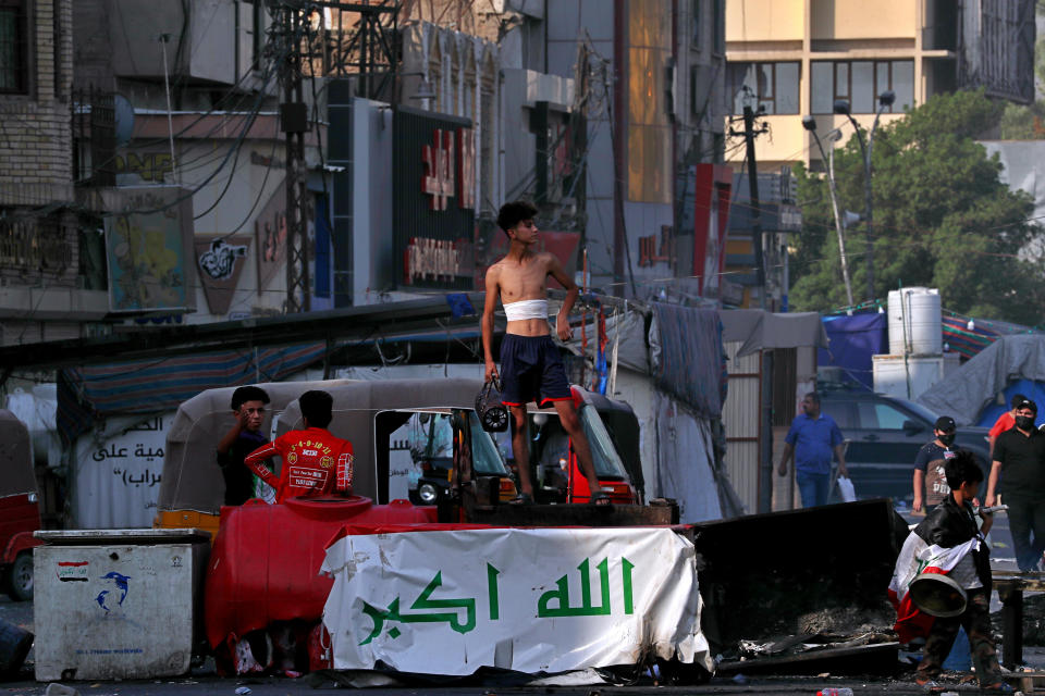 Anti-government protesters gather by barriers near Tahrir Square, Baghdad, Iraq, Monday, July, 27, 2020. Fresh violence erupted between demonstrators and Iraqi security forces in central Baghdad, human rights monitors and Iraqi security and health officials said on Monday, following months of quiet in the wake of the coronavirus pandemic. (AP Photo/Khalid Mohammed)