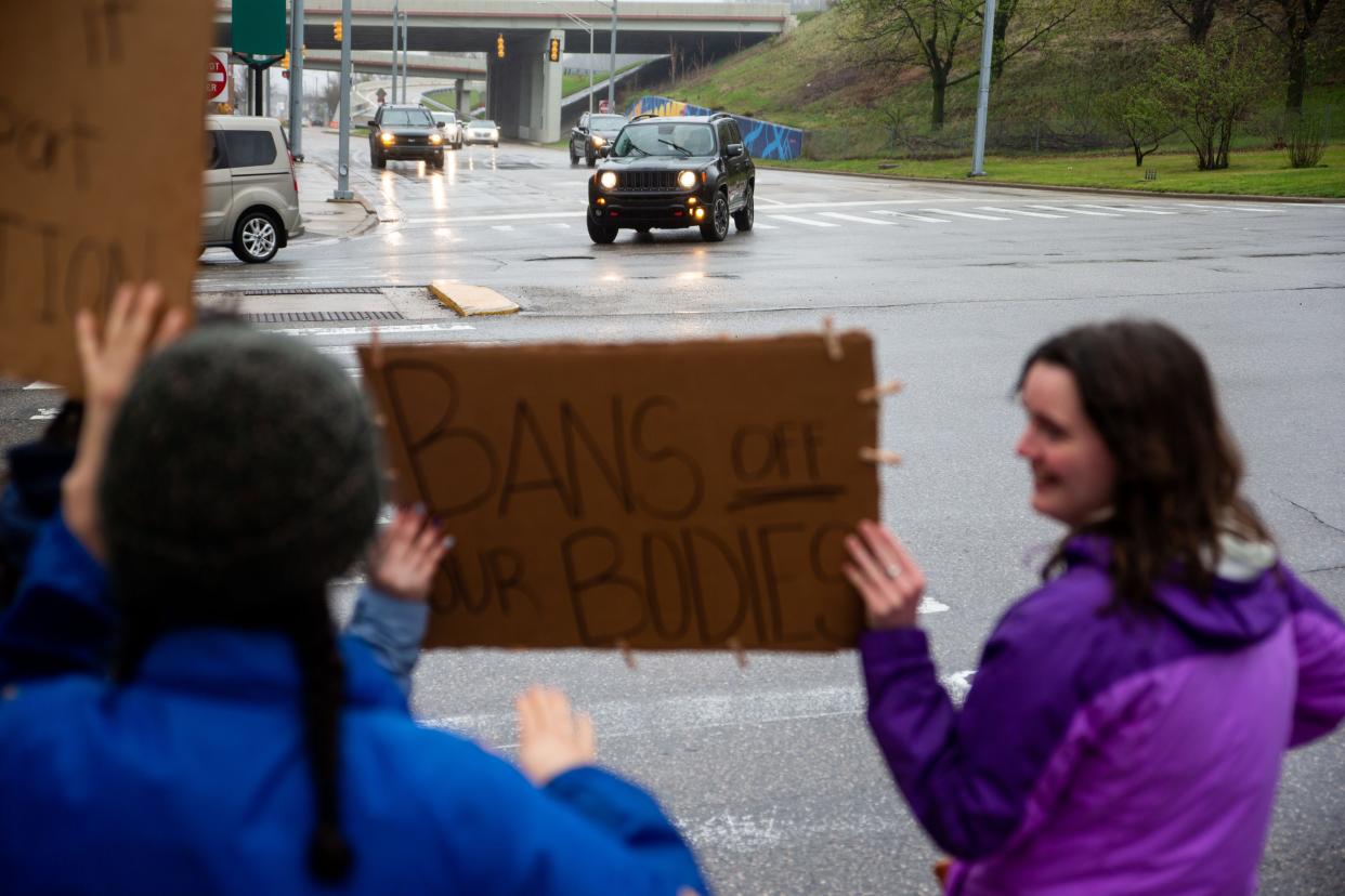 Protesters stand on the intersection of Michigan Street and Ottawa Avenue in support of abortion rights after the leaked draft opinion by the Supreme Court overturning Roe v. Wade Tuesday, May 3, 2022, outside of Gerald R. Ford Federal Building in downtown Grand Rapids.