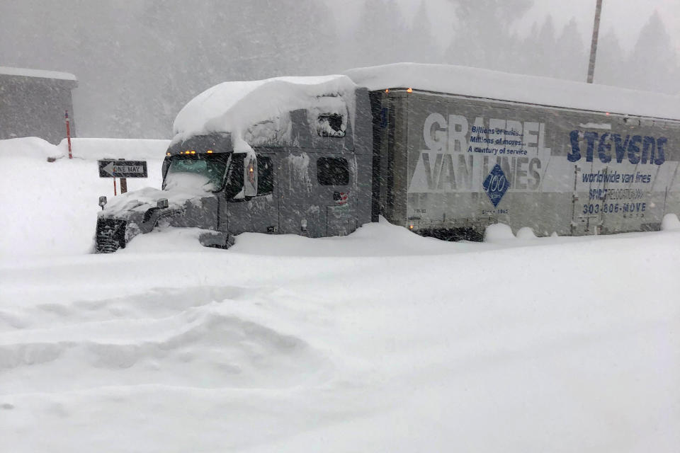 In this photo provided by Caltrans District 9, a tractor trailer that is stuck in heavy snowfall at Crestview along U.S. Hwy 395, closed in Mono County, Calif., Wednesday, Jan. 27, 2021. An atmospheric river storm pumped drenching rains into the heart of California on Thursday as blizzard conditions buried the Sierra Nevada in snow. (Andy Richard/Caltrans District 9 via AP)