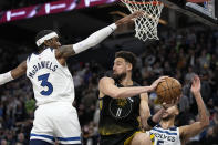 Golden State Warriors guard Klay Thompson (11) looks to pass while defended by Minnesota Timberwolves forward Jaden McDaniels (3), left, and forward Kyle Anderson during the second half of an NBA basketball game, Wednesday, Feb. 1, 2023, in Minneapolis. (AP Photo/Abbie Parr)