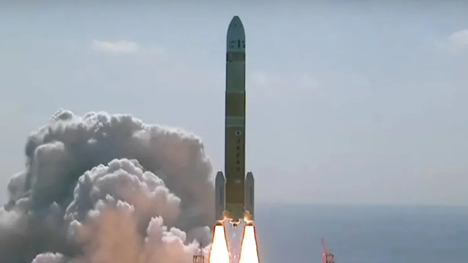  a orange rocket lifts off during day time as a huge cloud of smoke forms beneath it 