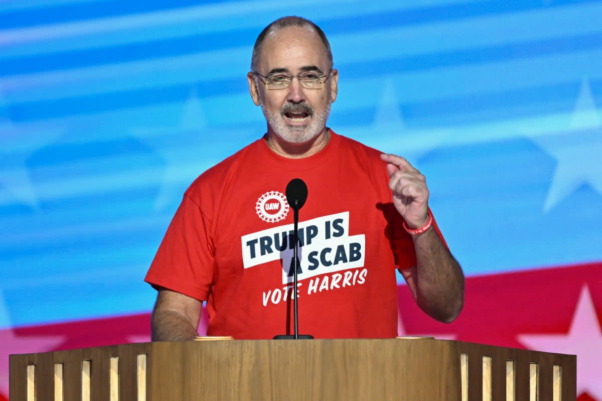 United Auto Workers union president Shawn Fain speaks to the Democratic National Convention on August 19. He removed his jacket revealing a T-shirt that read ‘Trump is a scab’ (AFP via Getty Images)