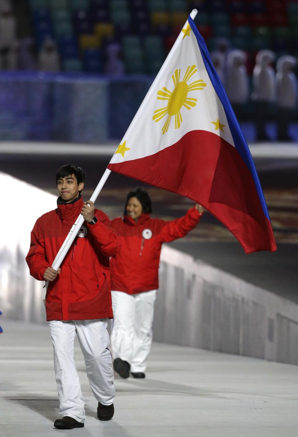 Michael Christian Martinez of the Philippines carries the national flag as he leads his team during the opening ceremony of the 2014 Winter Olympics in Sochi, Russia, Friday, Feb. 7, 2014. (AP Photo/Mark Humphrey)