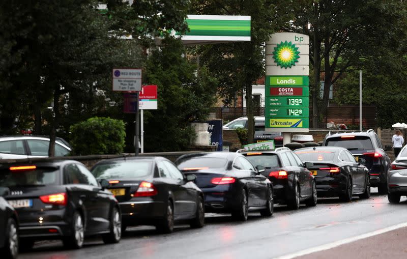 Vehicles queue to refill at a BP fuel station in London