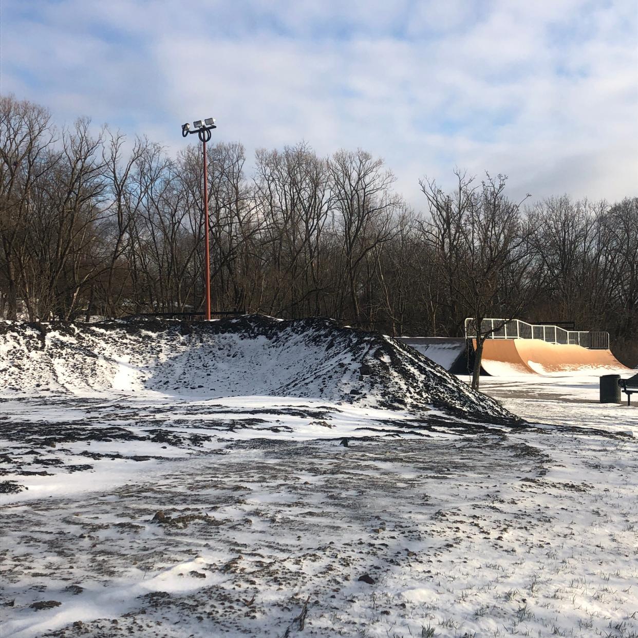 This mound of snow-covered dirt in Alliance's Memorial Park shows the early construction of a new pump track for bike riders. The work has stopped for the winter. Behind the mound is the Sean Scott Memorial Rotary Skate Park.