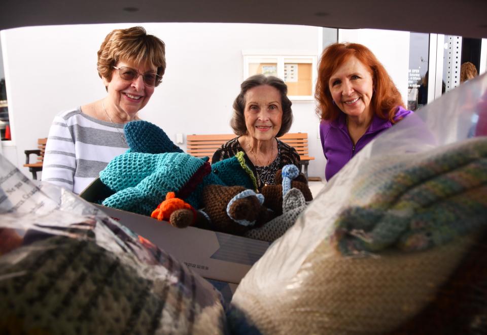 Rita Brooks, Marjorie Leonhardt and Linda Gotham unload a carload of donations at the Veterans Memorial Center on Merritt Island. They and other members of the Heritage Isle Crafters in Viera knitted and crocheted scarves, hats, quilts, blankets, tissue boxes and toys to be distributed by the Veterans Center and the The Voice of Hope.