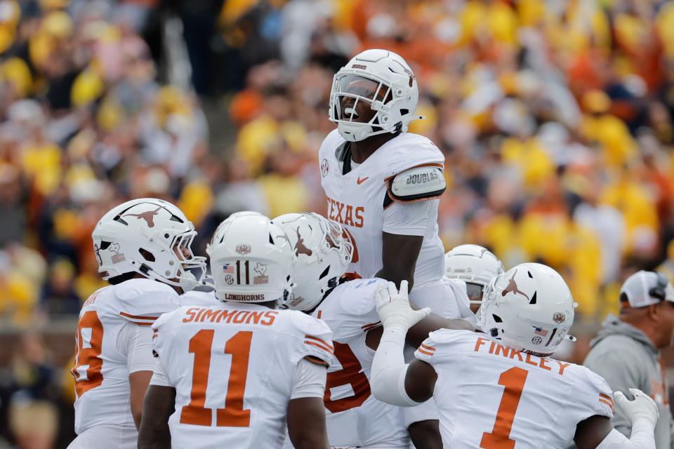 Texas defensive back Derek Williams Jr. celebrates his second-half interception with teammates in Saturday's 31-12 win over No. 9 Michigan at Michigan Stadium in Ann Arbor. It was the nation's first top-10 matchup of the season.