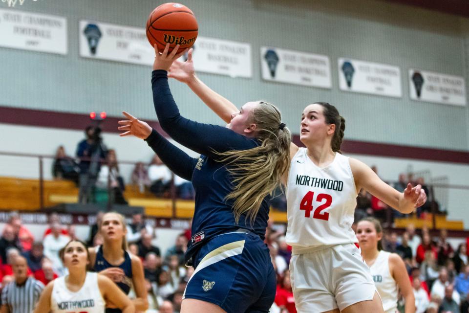 New Prairie's Kaylee Hoggard (55) drives past NorthWood's Claire Payne (42) during the girls regional championship game Saturday, Feb. 10, 2024 at Jimtown High School in Elkhart.