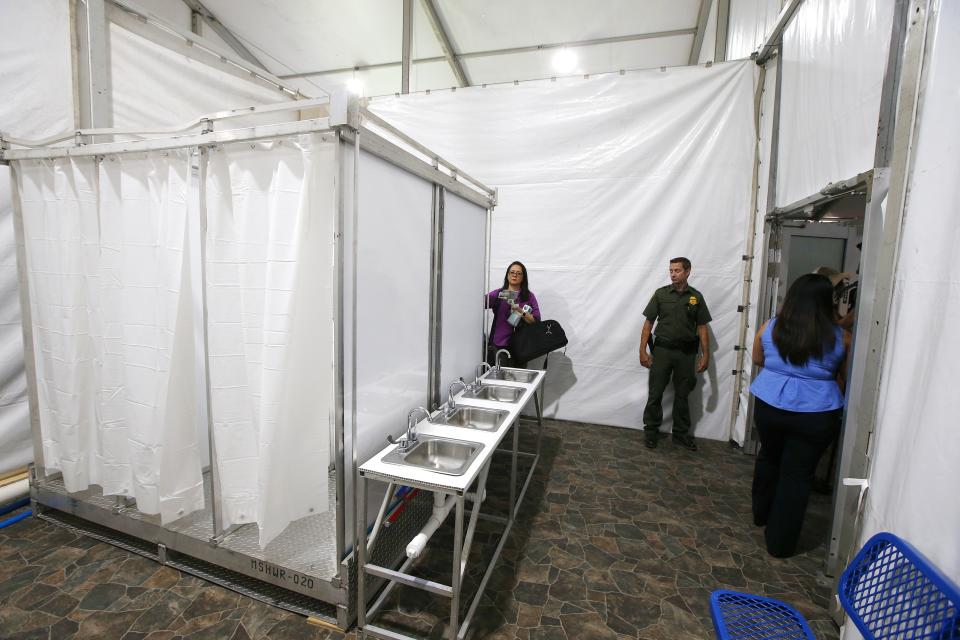 Shower stalls and sinks are seen as the U.S. Border Patrol unveiled a new 500-person tent facility during a media tour Friday, June 28, 2019, in Yuma, Ariz. The facility will be used to process detained immigrant children and families who cross the U.S. border. The Border Patrol says it will start placing families there on Friday night. (AP Photo/Ross D. Franklin)