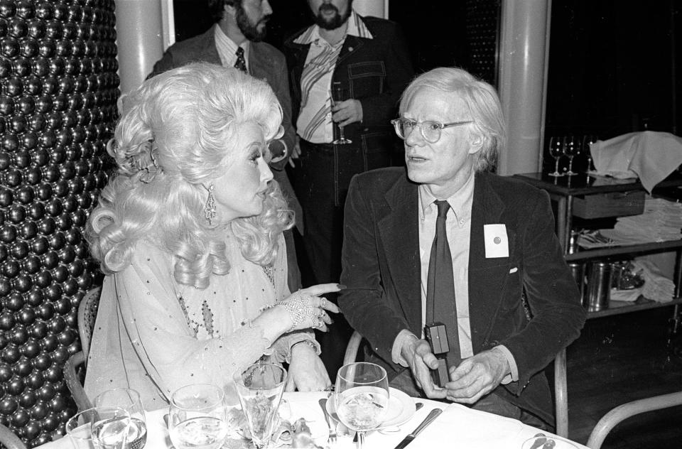 American Country musician Dolly Parton and Pop artist Andy Warhol (1928 - 1987) together at the Windows on the World restaurant, New York, New York, May 14, 1977. The event was an after party following Parton's performance at the Bottom Line. (Photo by Allan Tannenbaum/Getty Images)