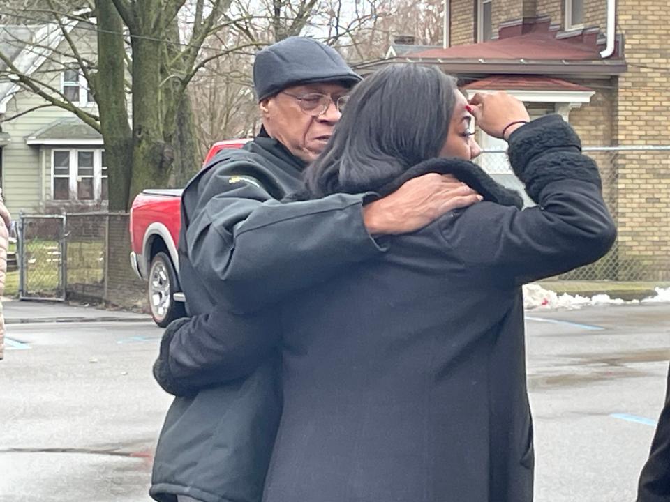 At a community event to memorialize the lives of six children lost in a fatal house fire, their father, David Smith, shares a moment with Dione Jones, a fifth-grade teacher and family friend.
