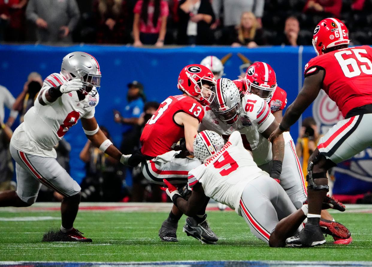 Dec 31, 2022; Atlanta, Georgia, USA; Ohio State Buckeyes defensive end Zach Harrison (9) tackles Georgia Bulldogs quarterback Stetson Bennett (13) in the third quarter during the Peach Bowl in the College Football Playoff semifinal at Mercedes-Benz Stadium. 