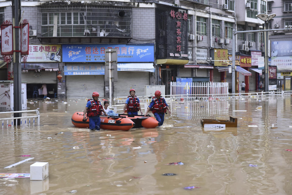 In this photo released by Xinhua News Agency, rescuers evacuate people stranded after flooding caused by heavy rain in the city of Jian'ou in southeast China's Fujian Province, June 19, 2022. (Huang Jiemin/Xinhua via AP)