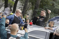 Brazil's President Jair Bolsonaro flashes a thumbs up as he arrives to take part in caravan of motorcycle enthusiasts in a show of support for Bolsonaro, in Sao Paulo, Brazil, Saturday, June 12, 2021. (AP Photo/Marcelo Chello)
