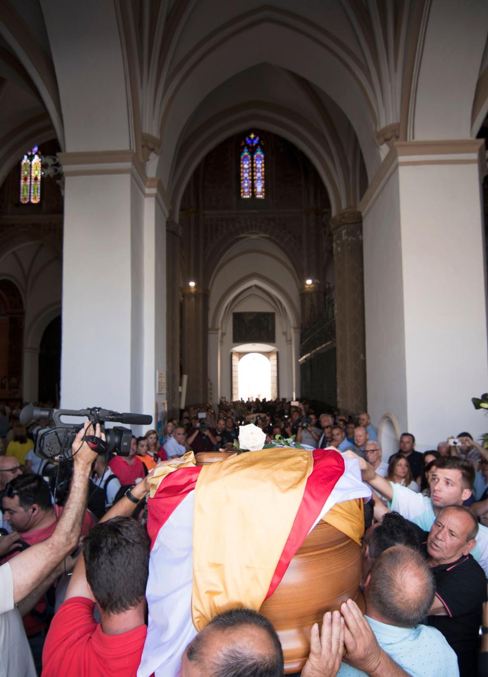 The coffin with the remains of Spanish football player Jose Antonio Reyes, covered with the flags of the village of Utrera and Sevilla FC football team, is carried on shoulders to the Santa Maria de Mesa church in Utrera, during the funeral for the footballer on June 3, 2019. - Former Arsenal, Real Madrid and Spain forward, Jose Antonio Reyes, 35, was killed in a car crash on June 1, 2019. Reyes shot to fame at Sevilla and secured a switch to Arsenal, where he was part of the unbeaten 'Invincibles' 2003-2004 Premier League winners, before spells at Real and Atletico Madrid. (Photo by CRISTINA QUICLER / AFP)        (Photo credit should read CRISTINA QUICLER/AFP/Getty Images)