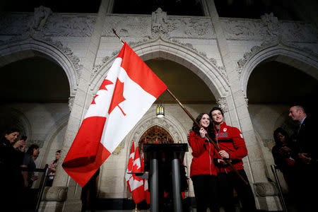 Ice dancers Tessa Virtue and Scott Moir pose with a Canadian flag after being named Canada's flag-bearers for the opening ceremony of the 2018 Pyeongchang Winter Olympic Games during an event on Parliament Hill in Ottawa, Ontario, Canada, January 16, 2018. REUTERS/Chris Wattie