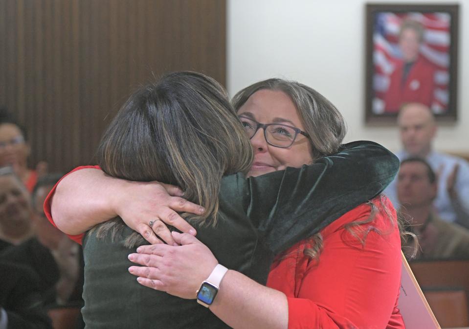 New Mansfield mayor Jodie Perry, in red, was sworn in by State Rep. John on Friday morning in council chambers, after which the two elected officials shared a lengthy hug.