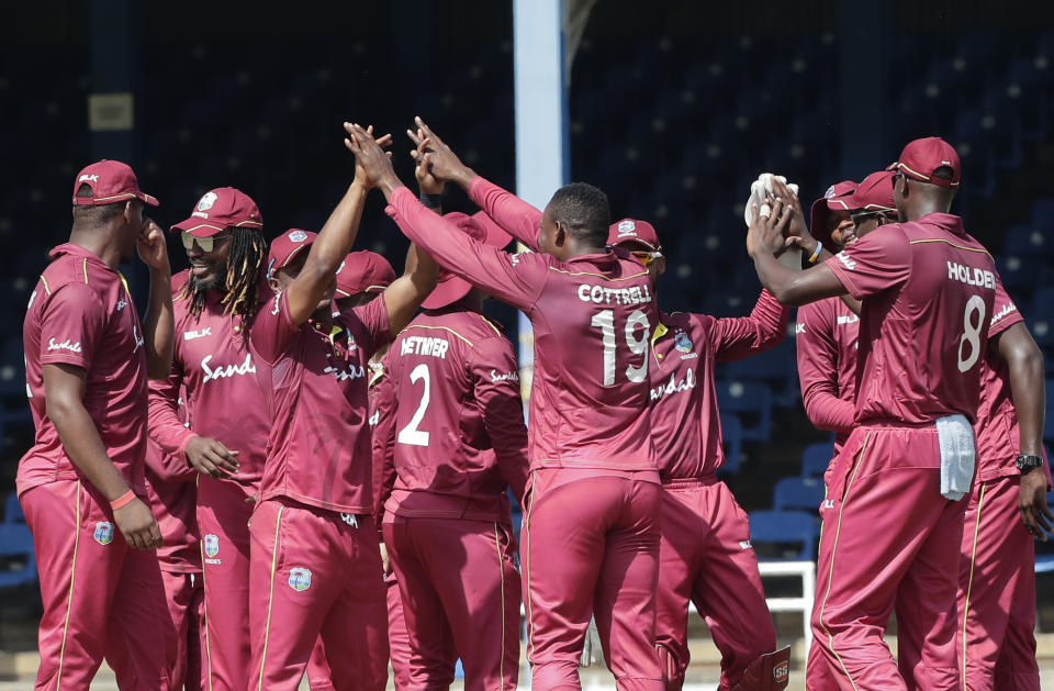 West Indies Sheldon Cottrell, 19, is congratulated by teammates after taking the wicket of India Shikhar Dhawan, who was trapped LBW for a 2 runs, during their second One-Day International cricket match in Port of Spain, Trinidad, Sunday, Aug. 11, 2019. (AP Photo/Arnulfo Franco)