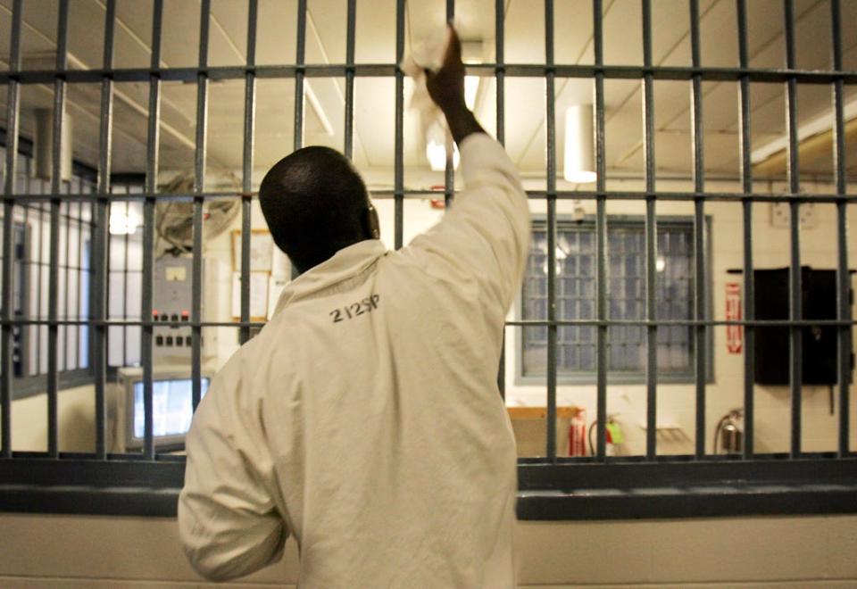 In this 2009 photo, an inmate cleans bars at a guard station in the maximum security unit at Tucker Prison near Tucker, Arkansas.