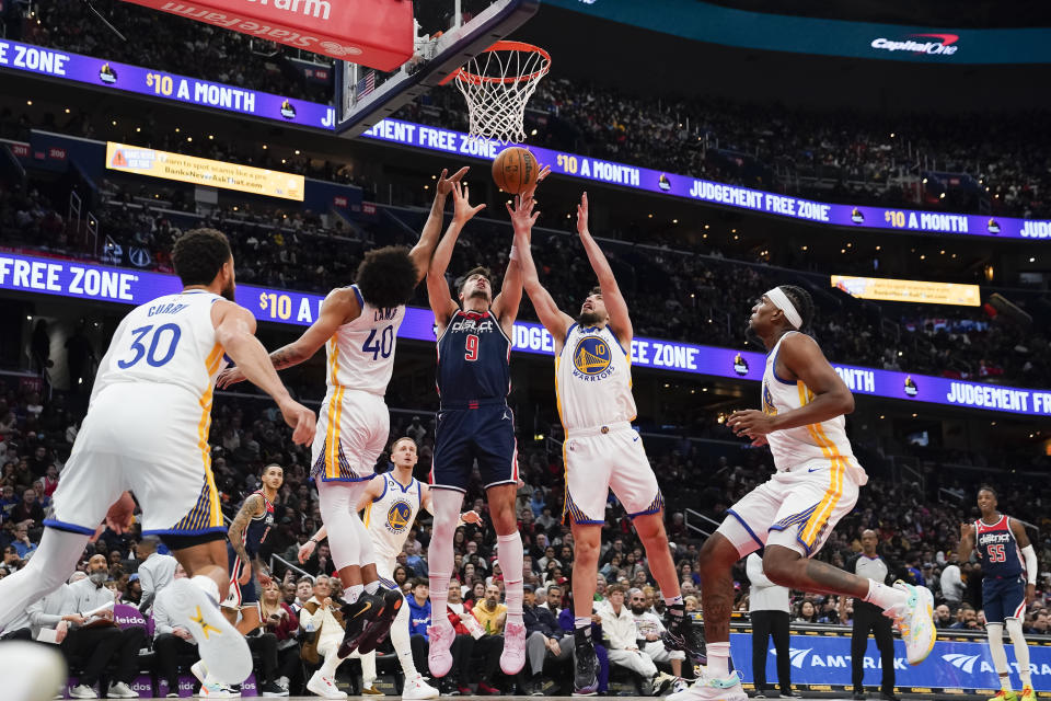 Washington Wizards forward Deni Avdija (9) goes up for a rebound against Golden State Warriors forward Anthony Lamb (40) and guard Ty Jerome (10) during the first half of an NBA basketball game, Monday, Jan. 16, 2023, in Washington. (AP Photo/Jess Rapfogel)