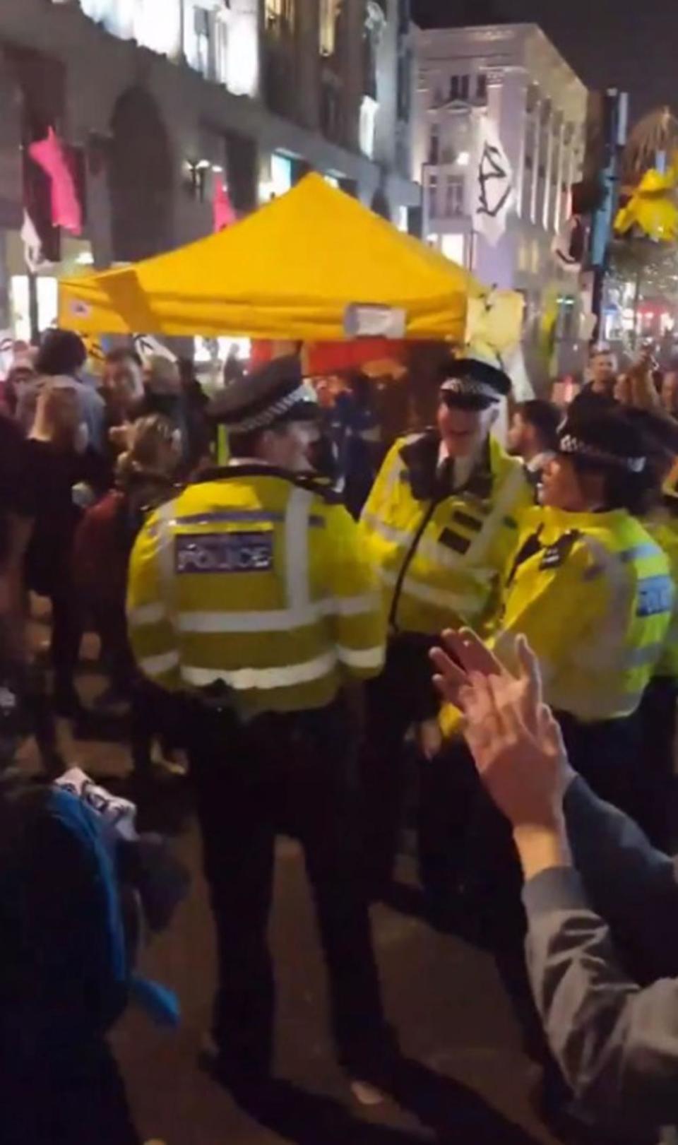 Police officers were filmed dancing alongside climate protesters who have brought disruption to London