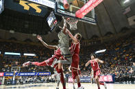 West Virginia guard Kedrian Johnson (0) makes a layup while being guarded by Oklahoma guard Joe Bamisile, left, and Oklahoma forward Sam Godwin, right, during the first half of an NCAA college basketball game in Morgantown, W.Va., Saturday, Feb. 4, 2023. (AP Photo/William Wotring)