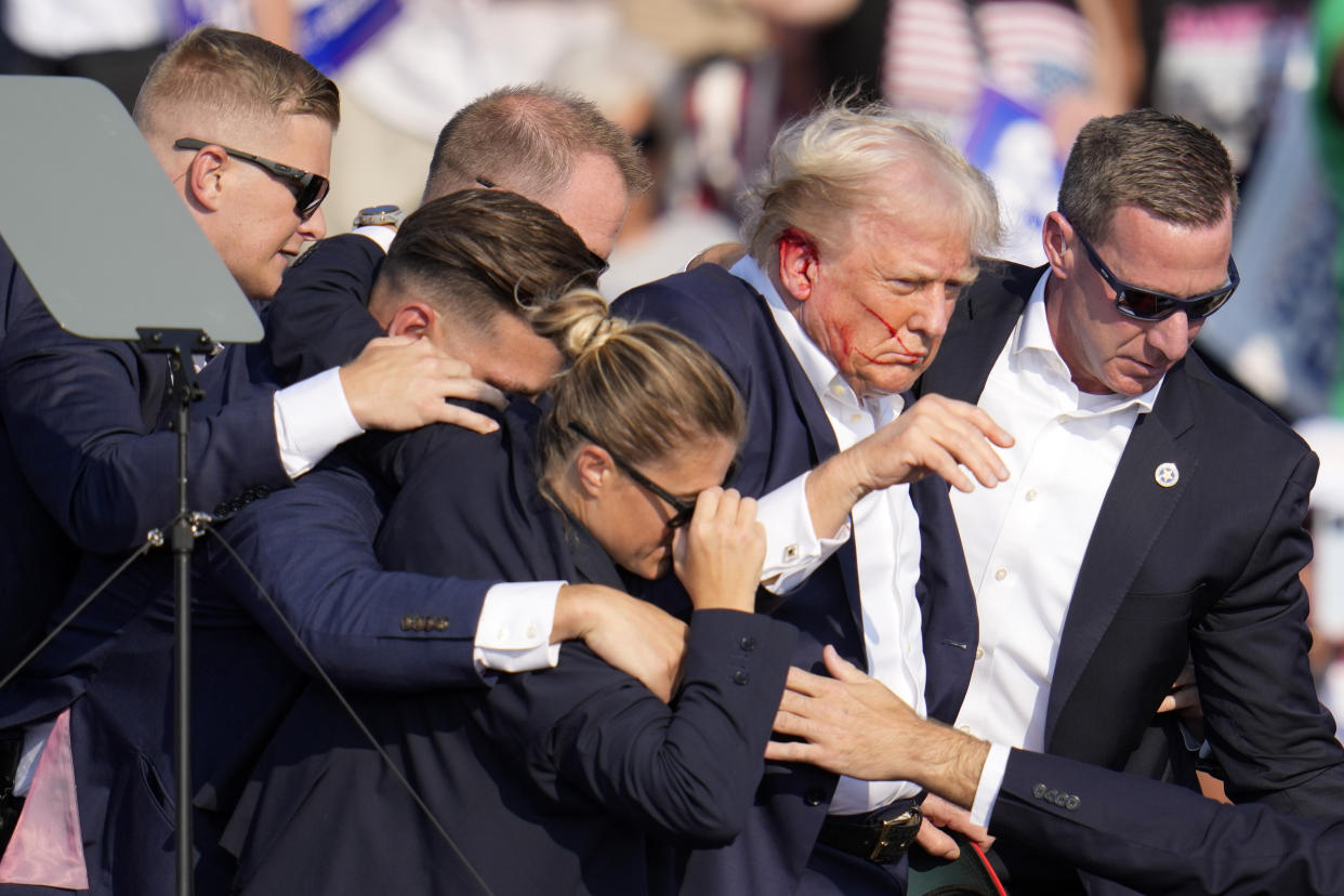 Republican presidential candidate former President Donald Trump is helped off the stage by U.S. Secret Service agents at a campaign event in Butler, Pa., on Saturday.