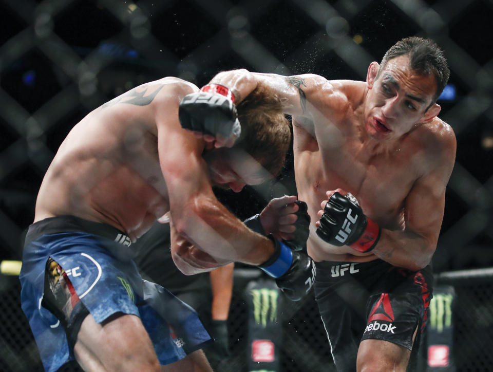 FILE - In this June 8, 2019, file photo, Tony Ferguson, right, punches Donald Cerrone, left, during their lightweight mixed martial arts bout at UFC 238 in Chicago. The UFC says Ferguson will fight Justin Gaethje for the interim lightweight title in the main event of UFC 249 on April 18, 2020. The mixed martial arts promotion announced the matchup Monday, April 6, 2020. Gaethje replaces lightweight champ Khabib Nurmagomedov, who is apparently unable to leave Russia during the coronavirus pandemic. (AP Photo/Kamil Krzaczynski, File)