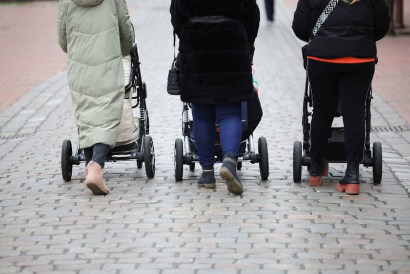 Three women push their baby carriages in the pedestrian zone on the market square in the center of Heide. The number of births and weddings in Germany fell to the lowest level in years in 2023, according to preliminary figures from the Federal Statistical Office Around 693,000 children were born in Germany last year, the lowest level since 2013. Christian Charisius/dpa