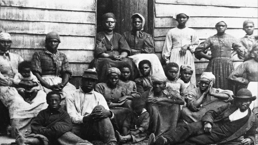 Portrait of Civil War ‘contrabands,’ fugitive slaves who were emancipated upon reaching the North, sitting outside a house, possible in Freedman’s Village in Arlington, Virginia, mid 1860s. Up to 1100 former slaves at a time were housed in the government established Freedman’s Village in the thirty years in which it served as a temporary shelter for runaway and liberated slaves. (Photo by Hulton Archive/Getty Images)