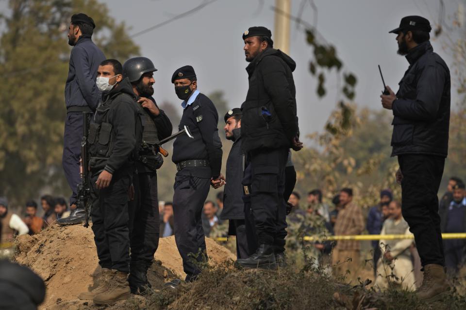 Police officers stand guard at the site of bomb explosion, in Islamabad, Pakistan, Friday, Dec. 23, 2022. A powerful car bomb detonated near a residential area in the capital Islamabad on Friday, killing some people, police said, raising fears that militants have a presence in one of the country's safest cities. (AP Photo/Anjum Naveed)