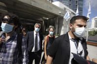 Aya Biran, second right, a paternal aunt of Eitan Biran, who survived a cable car crash in Italy that killed his immediate family, leaves court in Tel Aviv on Thursday, Sept. 23, 2021, after a hearing in the alleged kidnapping of her nephew. The boy's parents and younger sibling were among 14 killed in May when a cable car slammed into a mountainside in northern Italy. He is now the focus of a custody battle between his maternal grandparents in Israel and his paternal relatives in Italy. (AP Photo/Sebastian Scheiner)