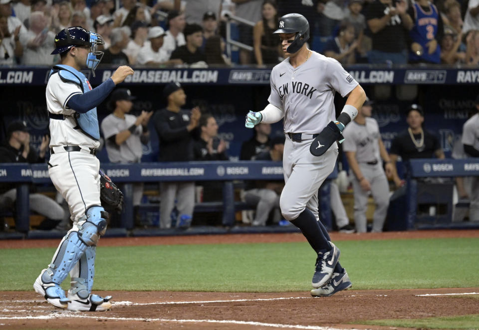 Tampa Bay Rays catcher Alex Jackson, left, watches the play as New York Yankees' Aaron Judge scores on Anthony Rizzo's single during the fourth inning of a baseball game Friday, May 10, 2024, in St. Petersburg, Fla. (AP Photo/Steve Nesius)