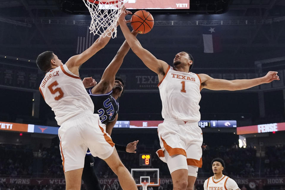 Texas-Arlington forward Shemar Wilson (22) is blocked as he drives to the basket against Texas forward Kadin Shedrick (5) and forward Dylan Disu (1) during the first half of an NCAA college basketball game in Austin, Texas, Monday, Jan. 1, 2024. (AP Photo/Eric Gay)