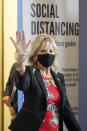 First lady Jill Biden waves to assembled local media as she makes her way past COVID education posters during a visit to vaccination site at Jackson State University in Jackson, Miss., Tuesday, June 22, 2021, as part of the Biden administration's nationwide tour to reach Americans who haven't been vaccinated and to promote vaccine education. (AP Photo/Rogelio V. Solis)