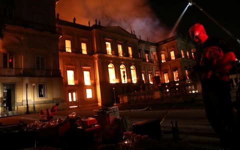 People rescue items during a fire at the National Museum of Brazil in Rio de Janeiro - Credit: Reuters