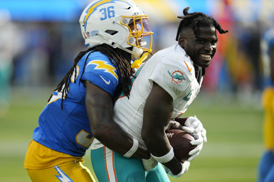 Miami Dolphins wide receiver Tyreek Hill (10) loses his helmet after making a catch next to Los Angeles Chargers cornerback Ja'Sir Taylor during the second half of an NFL football game Sunday, Sept. 10, 2023, in Inglewood, Calif. (AP Photo/Ashley Landis)