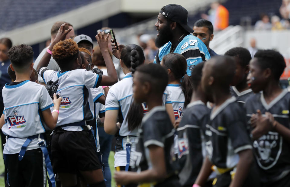 NFL player Mario Addison of the Carolina Panthers coaches a young team during the final tournament for the UK's NFL Flag Championship, featuring qualifying teams from around the country, at the Tottenham Hotspur Stadium in London, Wednesday, July 3, 2019. The new stadium will host its first two NFL London Games later this year when the Chicago Bears face the Oakland Raiders and the Carolina Panthers take on the Tampa Bay Buccaneers. (AP Photo/Frank Augstein)