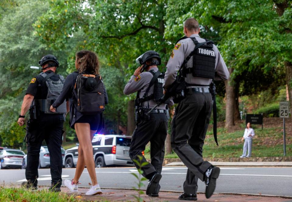 Heavily armed North Carolina State Troopers walk down South Road toward the Bell Tower on the University of North Carolina campus after a report of an armed and dangerous person on Monday, August 28. 2023 in Chapel Hill, N.C.
