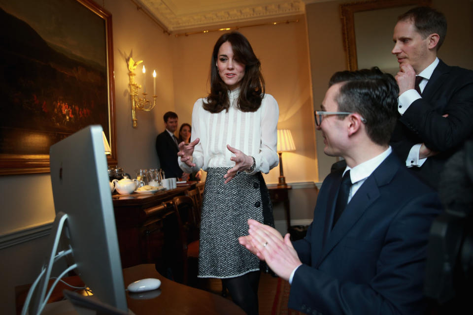 The Duchess of Cambridge, wearing a white turtleneck and bouclé skirt, in a pop-up newsroom in Kensington Palace where she’s guest-editing Huffington Post UK.