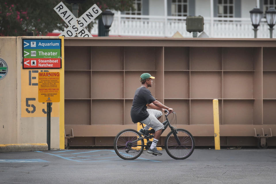 A cyclist rides past a flood gate that has been closed to keep the Mississippi River from inundating the French Quarter with storm surge from Hurricane Barry on July 12, 2019 in New Orleans, Louisiana. | Scott Olson—Getty Images