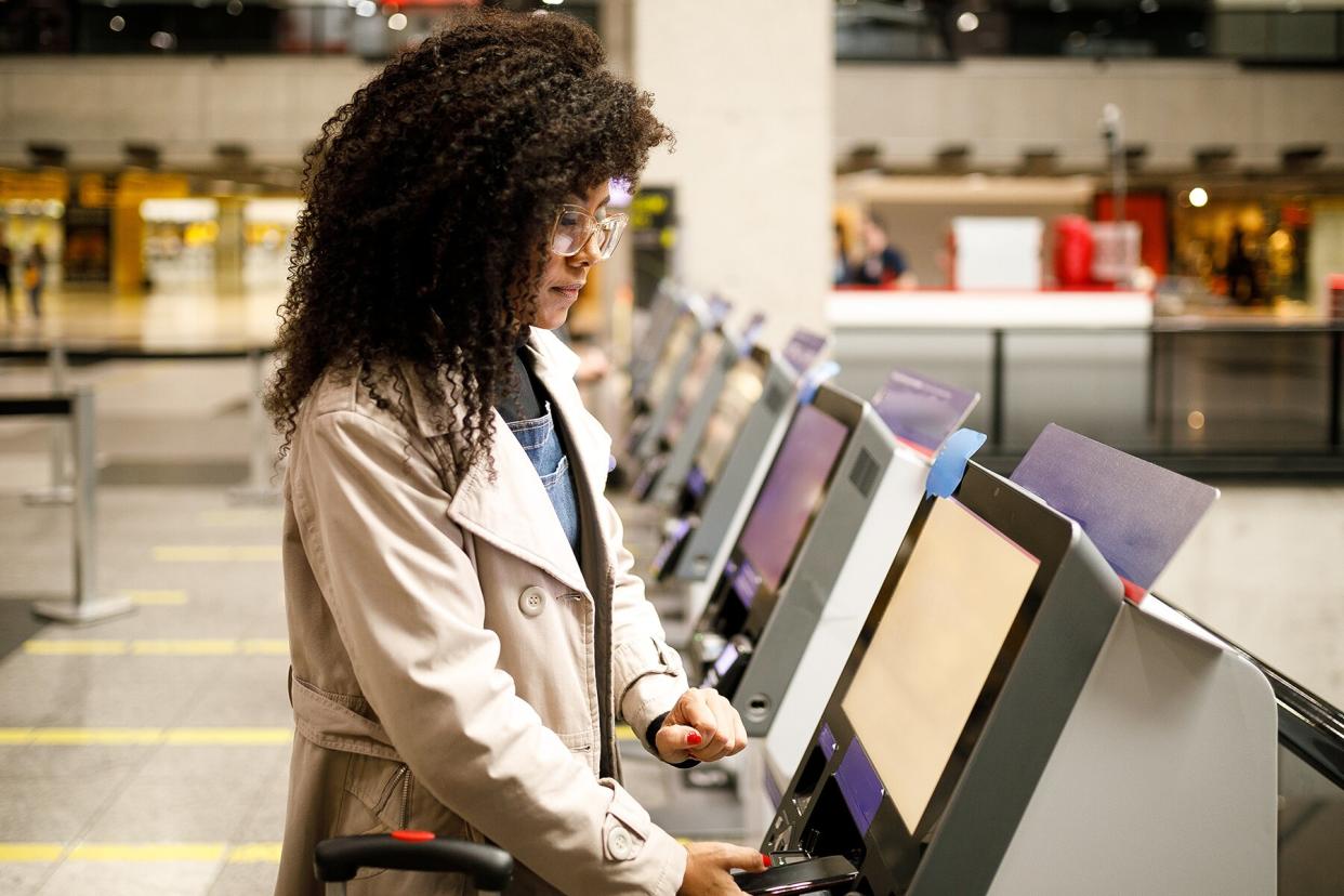 Woman doing self check in at the airport with mobile phone